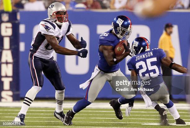 Antrel Rolle of the New York Giants intercepts a pass intended for Randy Moss of the New England Patriots during the first quarter on September 2,...