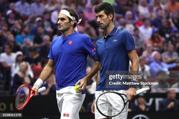 Team Europe Roger Federer of Switzerland and Team Europe Novak Djokovic of Serbia confer between points while playing Team World Jack Sock of the...