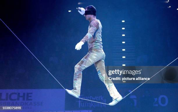 Acrobat Taros Hoi performs on a rope wearing a blindfold at the start of the European gymnastics show 'Feuerwerk der Turnkunst' in the EWE-Arena in...