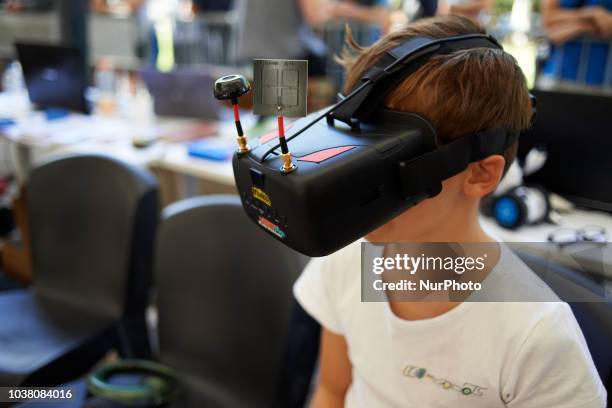 Boy pilots a robot car with a VR headset. A robots race took place in Toulouse. Machines are either cars or walking robots. They were supposed to run...