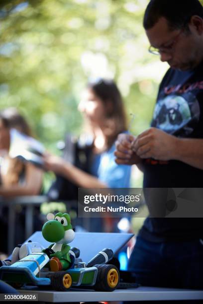 Man finalizes his robot car. A robots race took place in Toulouse. Machines are either cars or walking robots. They were supposed to run a 110 meters...