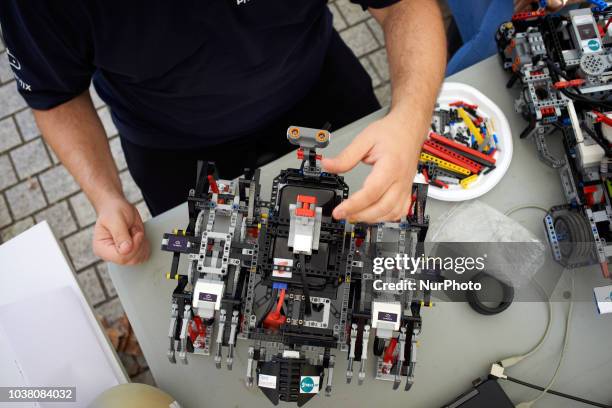 Man verifies his walking robot made in Lego. A robots race took place in Toulouse. Machines are either cars or walking robots. They were supposed to...