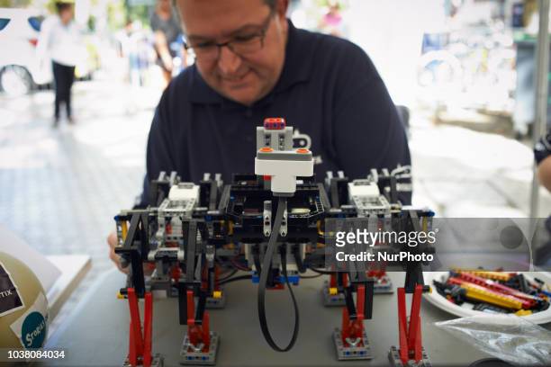 Man verifies his walking robot made in Lego. A robots race took place in Toulouse. Machines are either cars or walking robots. They were supposed to...