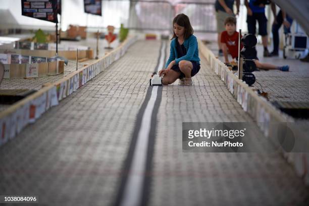 Girl prepares to launch her robot during a try. A robots race took place in Toulouse. Machines are either cars or walking robots. They were supposed...