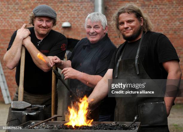 Actor Heinz Hoenig and smiths Tom Carstens and Denni Ludwig, work on nails at the "Bullermanns Schmiedeatelier" in Friesoythe, Germany, 8 May 2015....