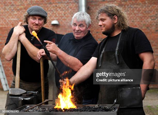 Actor Heinz Hoenig and smiths Tom Carstens , and Denni Ludwig , work on nails at the "Bullermanns Schmiedeatelier" in Friesoythe, Germany, 8 May...