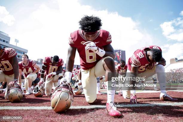 Tight End Tre' McKitty of the Florida State Seminoles takes a knee and says a prayer before the game against the Northern Illinois Huskies at Doak...