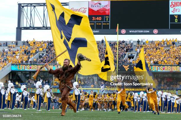The West Virginia Mountaineers mascot The Mountaineer and the cheerleaders lead the Mountaineers onto the field carrying the West Virginia State Flag...