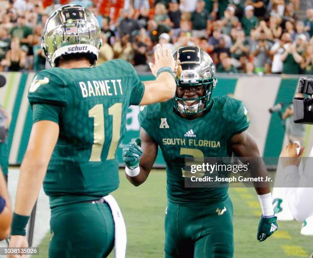 Quarterback Blake Barnett of the South Florida Bulls celebrates with teammate wide receiver Darnell Salomon after the two connected for a touchdown...