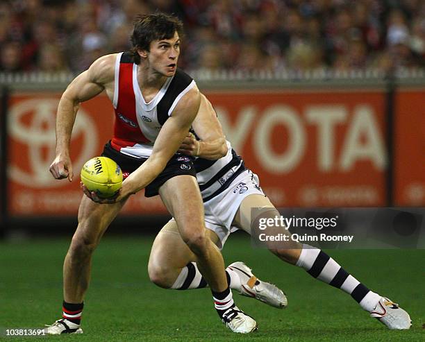 Farren Ray of the Saints handballs whilst being tackled by James Kelly of the Cats during the AFL Second Qualifying Final match between the Geelong...