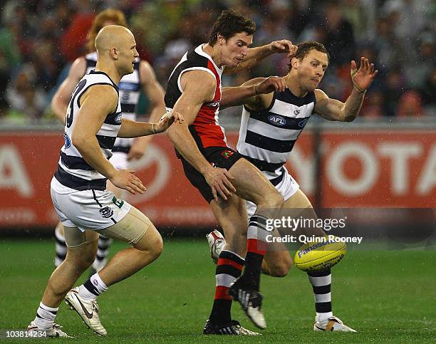 Lenny Hayes of the Saints kicks whilst being tackled by James Kelly of the Cats during the AFL Second Qualifying Final match between the Geelong Cats...