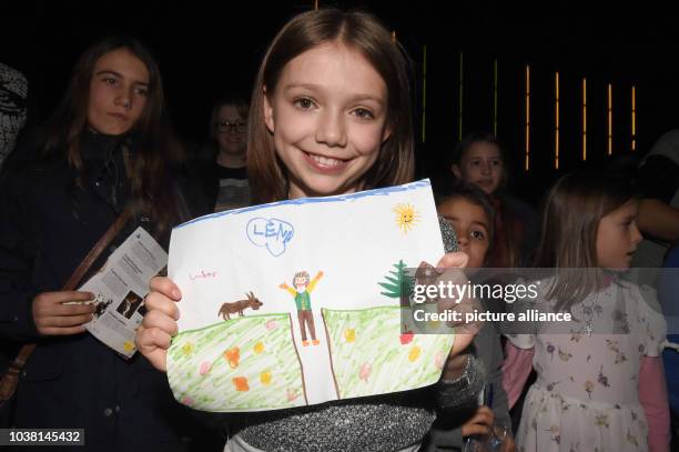 Actress Anuk Steffen poses with a drawing made ba young artist 'Lena' during the German premiere of 'Heidi' in the Mathaeser Kino in Munich, Germany,...