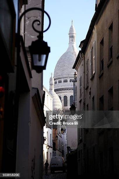 dome of sacre-coeur basilica seen from narrow street in montmartre. - sacré coeur paris photos et images de collection