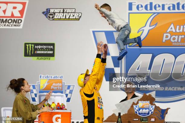 Kyle Busch, driver of the M&M's Toyota, celebrates in Victory Lane with wife Samantha and son Brexton after winning the Monster Energy NASCAR Cup...