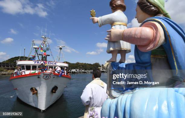 A fishing vessel with family of the owners on board nears the Madonna - a replica statue of the Santa Maria Di Porto Salvo, the guardian of safe...