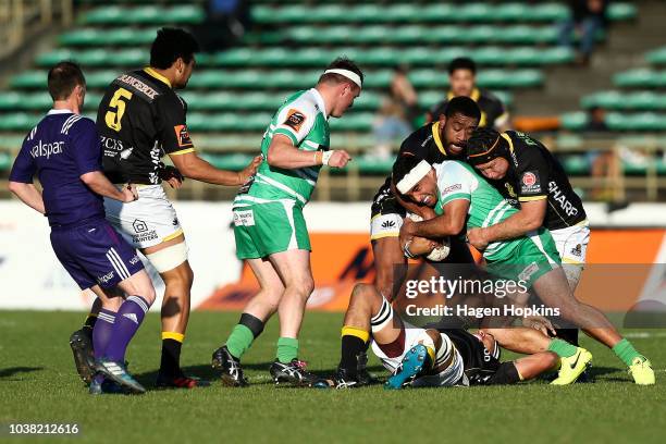 Adrian Wyrill of Manawatu is tackled by Tolu Fahamokioa and Thomas Waldrom of Wellington during the round six Mitre 10 Cup match between Manawatu and...