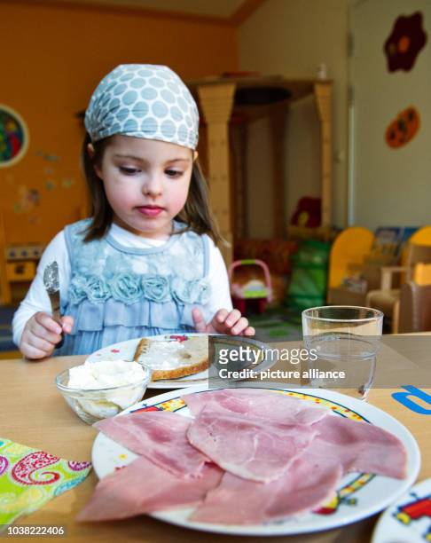 Alba Aderes eats an open sandwich at daycare centre 'Wichtel Akademie' in Munich, Germany, 24 April 2013. The daycare centre has made itself...