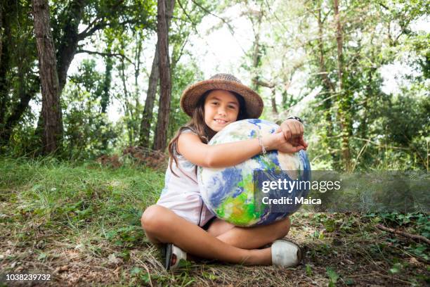 little girl embracing world globe - world environment stock pictures, royalty-free photos & images