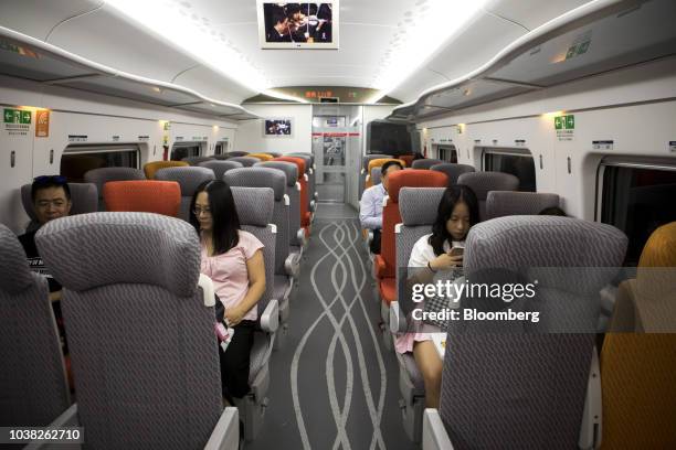 Passengers sit onboard a second-class coach of a Guangzhou-Shenzhen-Hong Kong Express Rail Link Vibrant Express train, operated by MTR Corp.,...