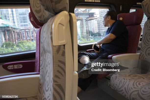 Passenger looks out from a first-class coach of a Guangzhou-Shenzhen-Hong Kong Express Rail Link Vibrant Express train, operated by MTR Corp.,...