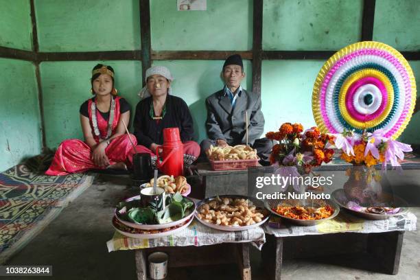 Nepali Limbu couple and their daughter sit in their home by a variety of food prepared for the Bhai Tika Festival in the Khyungte Village in Yuksom ,...