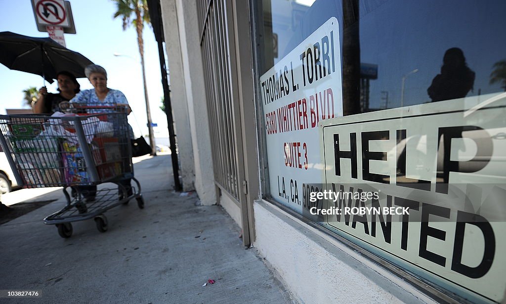 Two women walk past a beauty salon with