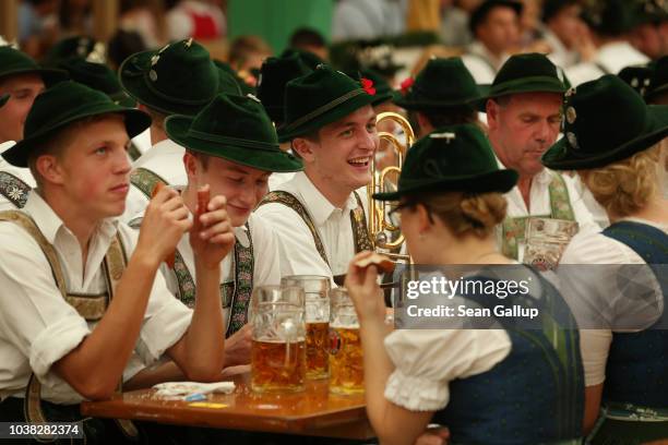 Members of a traditional Bavarian marching band drink beer in the Armbrustschuetzenzelt tent following the Oktoberfest parade of costumes of folk and...