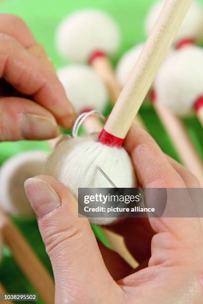 An employee sews felt to the head of a timpani mallet in the Rohema conductor's baton manufacturer in Marneukirchen, Germany, 25 February 2016....