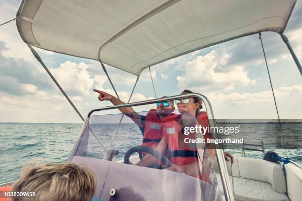 père et enfants circonscription un bateau sur le lac de garde - bateau à moteur photos et images de collection