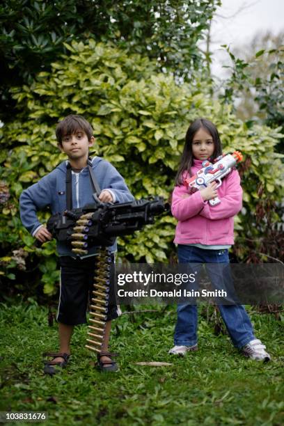 boy and girl with toy guns in garden - pakistani boys stockfoto's en -beelden