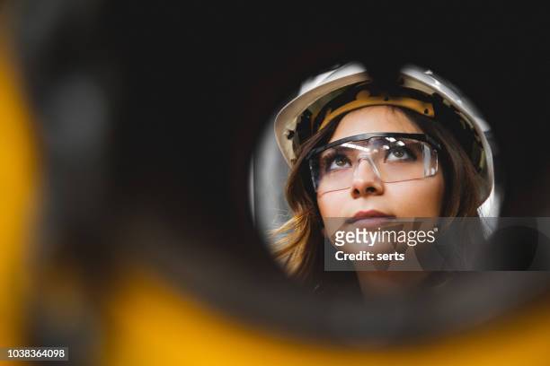 portret van jonge mooie ingenieur vrouw die werkt in fabrieksgebouw. - factory workers stockfoto's en -beelden