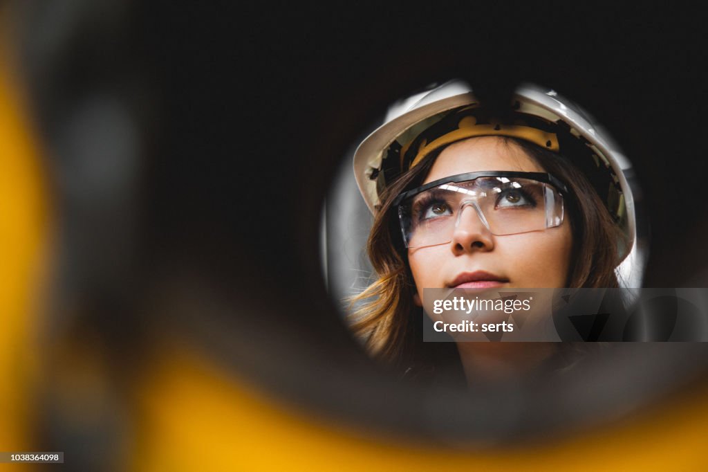 Portrait of young beautiful engineer woman working in factory building.