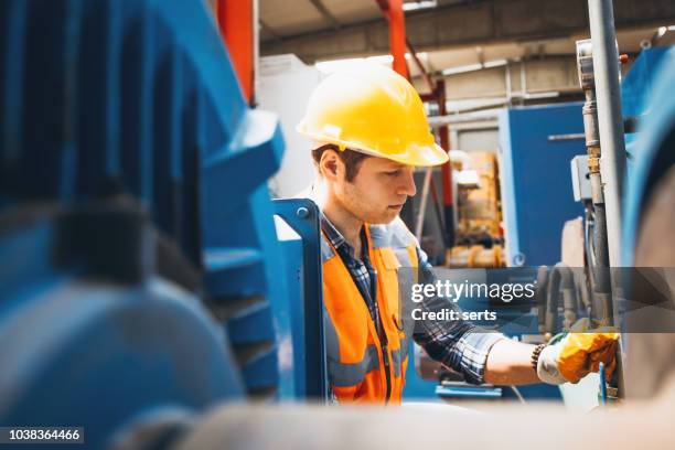 porträt von manuel arbeiter jüngling mit kugelhähne in fabrik arbeiten - funktionskleidung stock-fotos und bilder