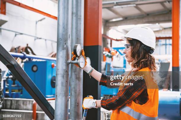 retrato de joven empresaria trabajando con válvulas de bola en fábrica - pressure gauge fotografías e imágenes de stock