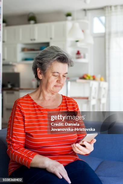senior vrouw met behulp van mobiele telefoon - kort haar stockfoto's en -beelden
