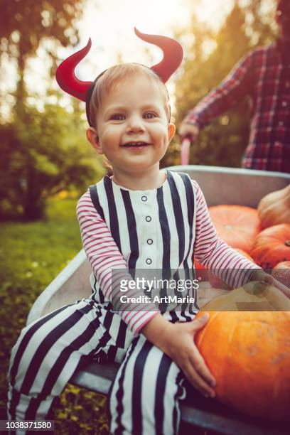 lindo niño y su padre con calabazas en otoño - disfraz de diablo fotografías e imágenes de stock