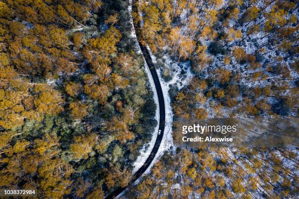 car driving on snow road aerial - snow mountain stock pictures, royalty-free photos & images