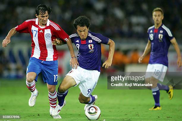 Shinji Okazaki of Japan and Aureliano Torres of Paraguay compete for the ball during the international friendly match between Japan and Paraguay at...