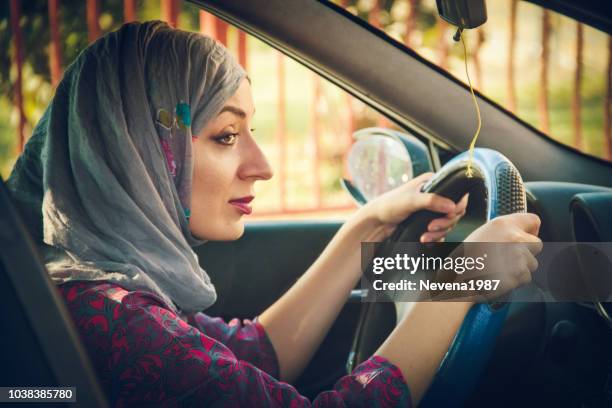 muslim woman driving a car and smiling - arab woman driving stock pictures, royalty-free photos & images