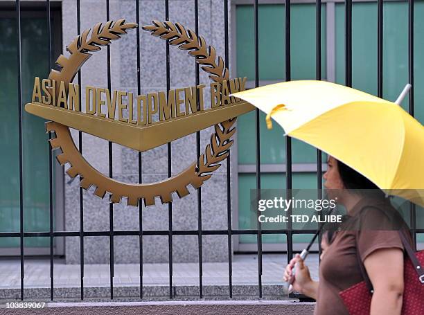 Pedestrian walks past a logo of Asian Development Bank displayed outside its headquarters in Manila on September 2, 2010. The Philippines said it...