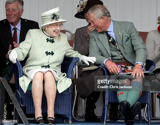 Queen Elizabeth II and Prince Charles, Prince of Wales laugh as they watch the tug-of-war during the Braemar Highland Games at The Princess Royal and...