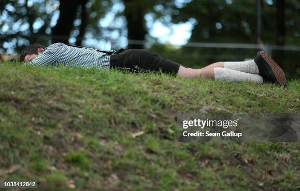 Reveler lies sleeping near beer tents on the second day of the 2018 Oktoberfest beer festival on September 23, 2018 in Munich, Germany. This year's...