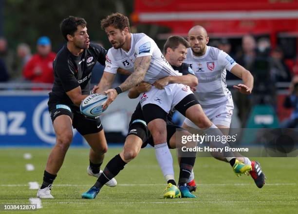 Danny Cipriani of Gloucester tackled by Richard Wigglesworth and Sean Maitland of Saracens during the Gallagher Premiership Rugby match between...