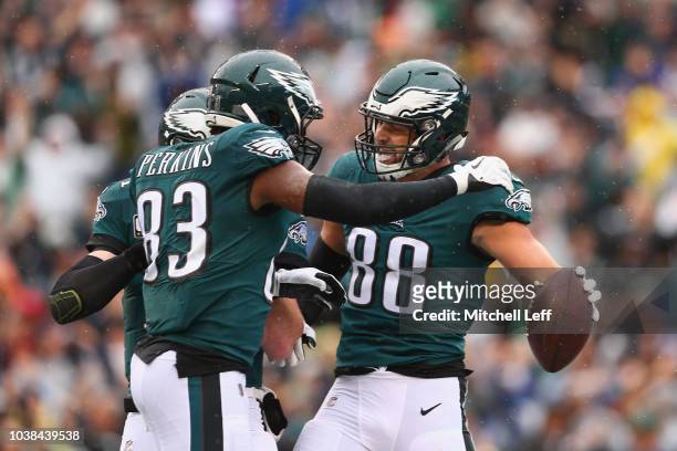 Tight end Dallas Goedert of the Philadelphia Eagles celebrates with teammates tight end Josh Perkins and quarterback Carson Wentz after Goedert made...