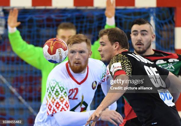 Belarus's Viachaslau Shumak and Germany's Paul Drux and Jannik Kohlbacher during the men's Handball World Cup match between Belarus and Germany in...