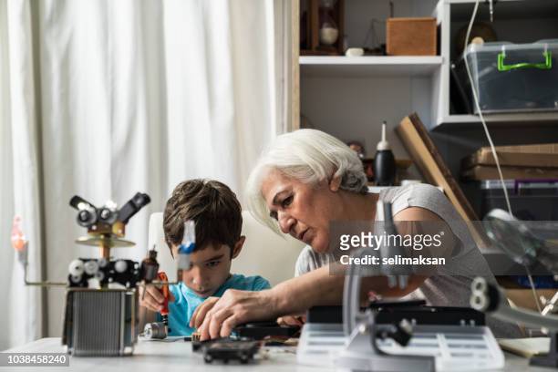 liten pojke och mormor bygga robot - kit bildbanksfoton och bilder