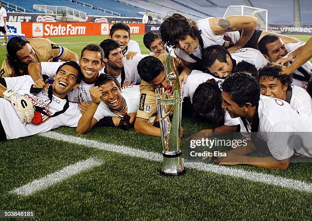 Monarcas Morelia team members dive at the trophy they won the SuperLiga 2010 championship game on September 1, 2010 at Gillette Stadium in Foxboro,...