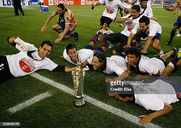 Monarcas Morelia team members dive at the trophy they won the SuperLiga 2010 championship game on September 1, 2010 at Gillette Stadium in Foxboro,...