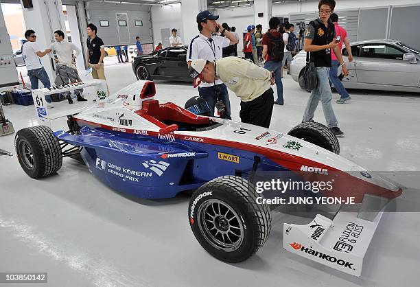 Visitor looks on an F1 show car on display at a pit at the Korean International Circuit under construction for the upcoming Korean Formula One Grand...