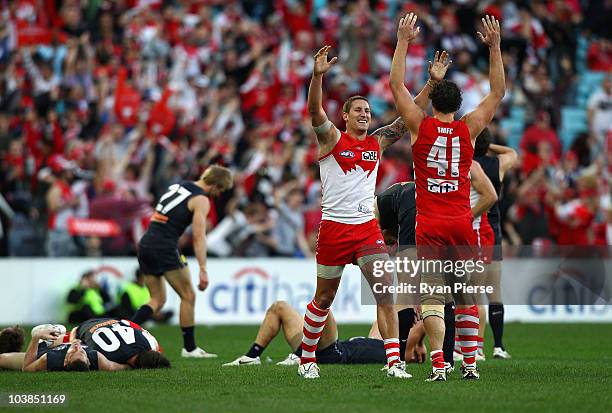 Jesse White and Shane Mumford of the Swans celebrate on the final siren as the Blues look dejected during the AFL First Elimination Final match...